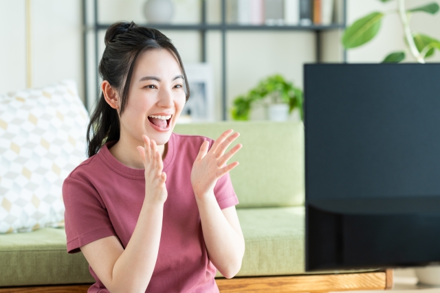 リビングでテレビを見る若い女性